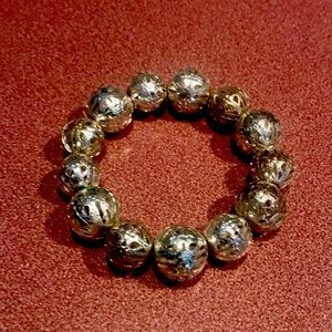 Very light weight stretch bracelet beads are silver with cut out designs on them